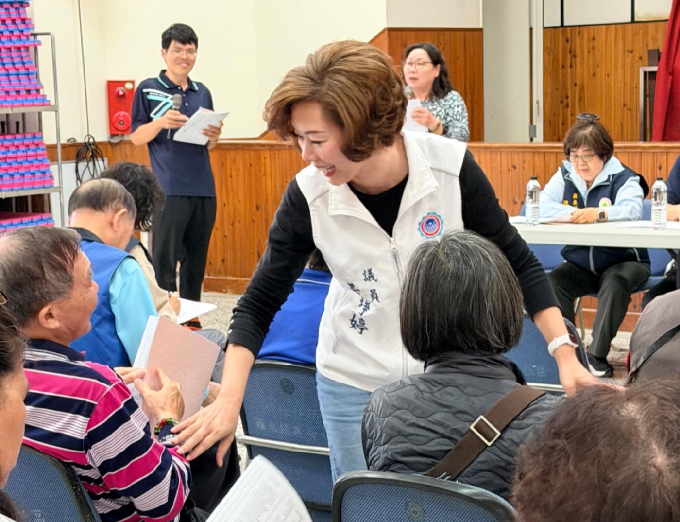 黃琤婷在社區活動中彎下身和長者說話